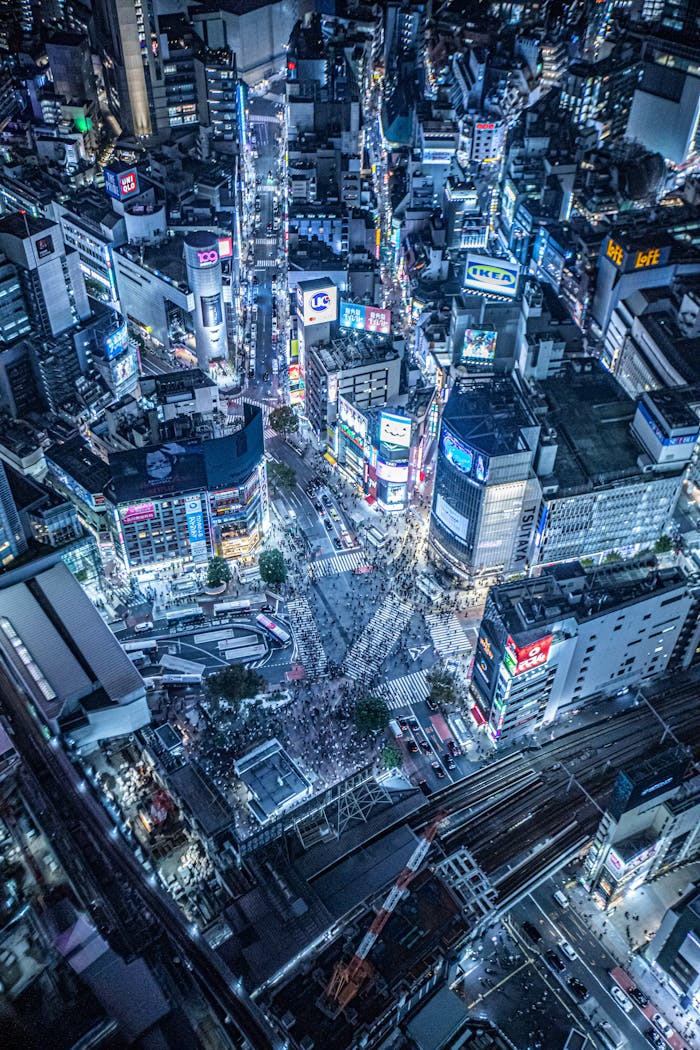 about-bg Vibrant aerial cityscape showcasing the bustling Shibuya Crossing at night in Tokyo, Japan.